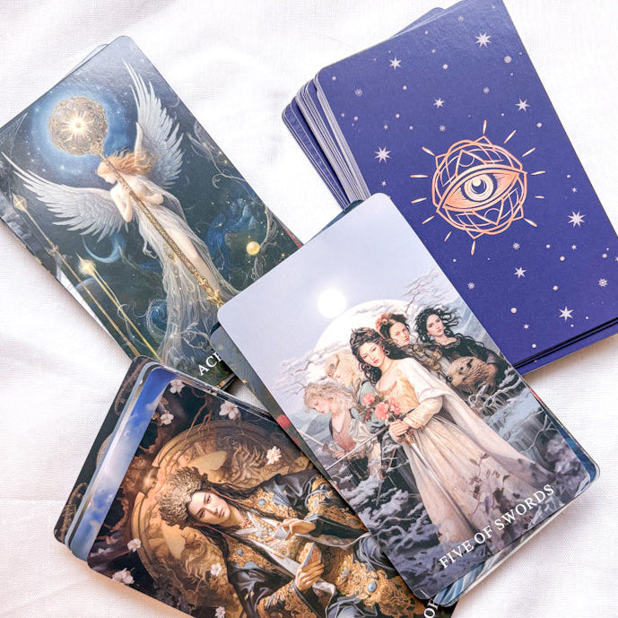 Set of tarot cards with artistic designs on a white surface