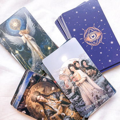 Set of tarot cards with artistic designs on a white surface