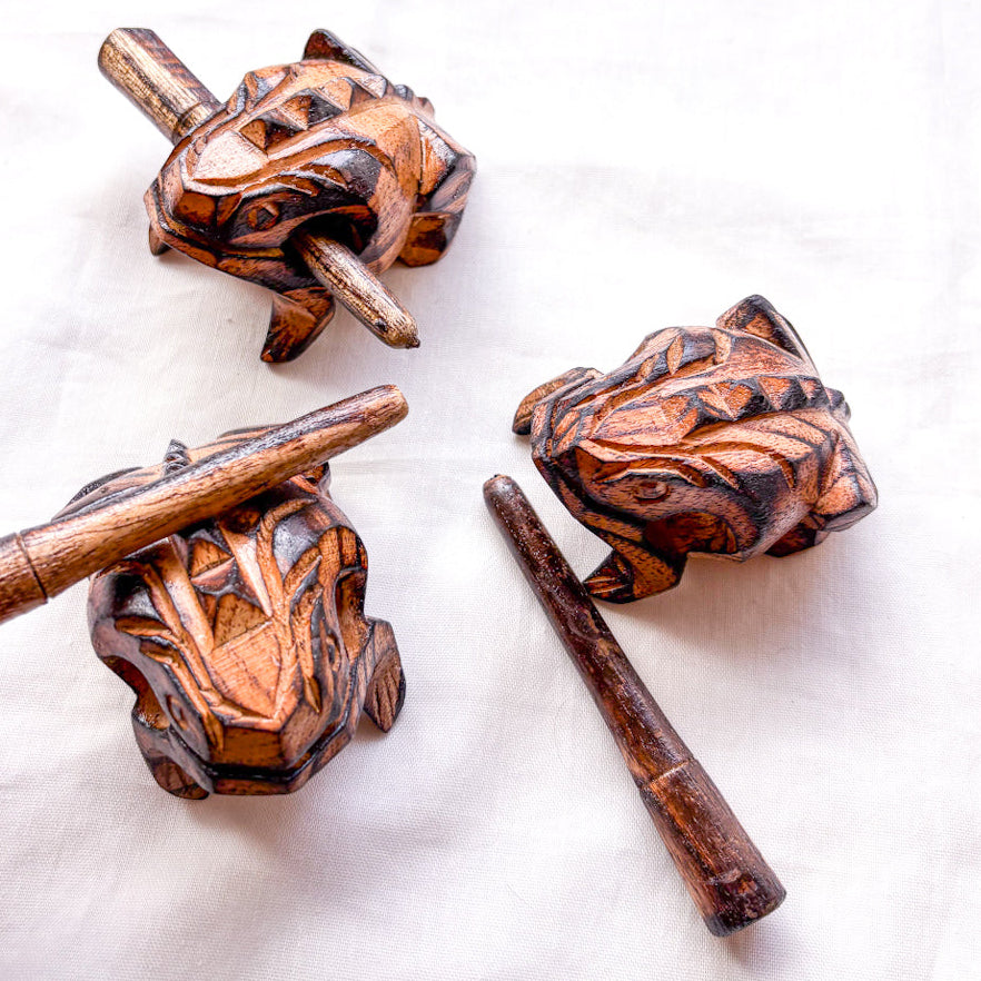 Wooden frog-shaped tools on a white background