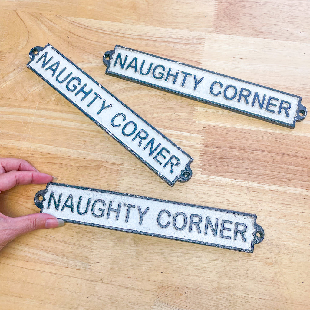 Naughty corner cast iron wall sign